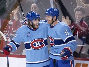 Canadiens' Mike Hoffman (68) and defenceman Mike Matheson celebrate Matheson's overtime goal to win the game 4-3 against the New York Islanders in Montreal on Saturday, Feb. 11, 2023.