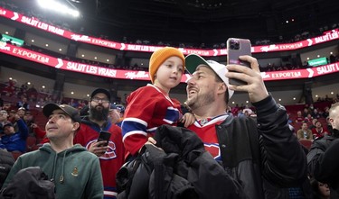 A young Habs fans gets a selfie taken by his father during the pregame warmup skate at the Bell Centre in Montreal on Saturday, February 11, 2023. The boy managed to get a puck from a New York Islanders player.