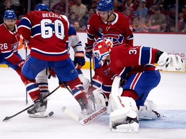 Canadiens' Alex Belzile (60) breaks up a shot on Canadiens goaltender Jake Allen against the Edmonton Oilers in Montreal on Sunday, Feb. 12, 2023. Canadiens defenceman Johnathan Kovacevic (26) and defenceman Jordan Harris (54) are also seen.