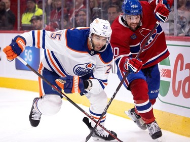 Canadiens' Alex Belzile (60) prevents Edmonton Oilers defenceman Darnell Nurse (25) from getting his stick on the puck in Montreal on Sunday, Feb. 12, 2023.