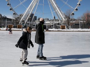 People enjoy the staking rink below the big wheel in Old Montreal on a very sunny morning Feb. 13, 2023.
