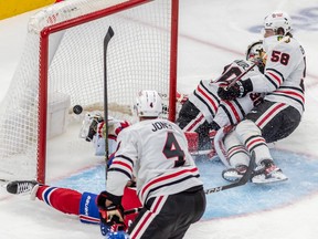 Chicago Blackhawks goaltender Jaxson Stauber (30) is crashed into by teammate Chicago Blackhawks right wing MacKenzie Entwistle (58) after being scored on by Montreal Canadiens right wing Joel Armia (40) during 3rd period NHL action at the Bell Centre in Montreal on Tuesday Feb. 14, 2023.