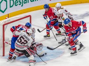 Montreal Canadiens centre Nick Suzuki fights for the loose puck in front of Chicago Blackhawks goaltender Jaxson Stauber during third period at the Bell Centre in Montreal on Feb. 14, 2023.