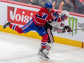Montreal Canadiens centre Nick Suzuki (14) checks Chicago Blackhawks centre Philipp Kurashev (23) during 2nd period NHL action at the Bell Centre in Montreal on Tuesday Feb. 14, 2023.