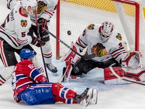 Montreal Canadiens right wing Evgenii Dadonov (63) is knocked to the ice in front of Chicago Blackhawks goaltender Petr Mrazek (34) with defenseman Connor Murphy (5) looking on during 2nd period NHL action at the Bell Centre in Montreal on Tuesday Feb. 14, 2023.