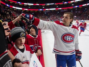 Chris Wideman hands out pucks to fans at the Montreal Canadiens' skills competition at the Bell Centre in Montreal on Feb. 19, 2023.