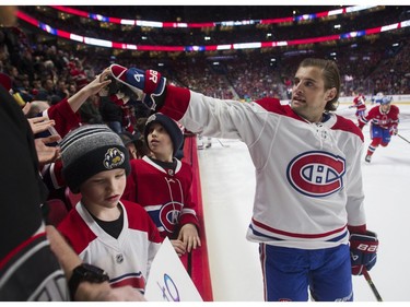 Chris Wideman hands out pucks to fans at the Canadiens skills competition at the Bell Centre in Montreal on Sunday, Feb. 19, 2023.