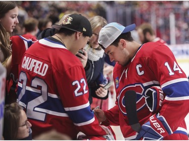 Canadiens captain Nick Suzuki signs autographs at the Canadiens skills competition at the Bell Centre in Montreal on Sunday, Feb. 19, 2023.