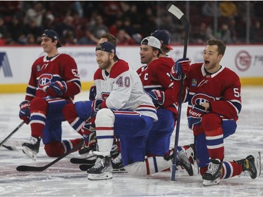 Canadiens players, from the left: Justin Barron, Joel Armia,  Nick Suzuki and Jordan Harris react as they watch goalie Jake Allen's shooting skills at the Canadiens skills competition at the Bell Centre in Montreal on Sunday, Feb. 19, 2023.