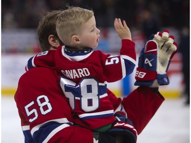 Canadiens defenceman David Savard and one of his children wave to fans at the Canadiens skills competition at the Bell Centre in Montreal on Sunday, Feb. 19, 2023.