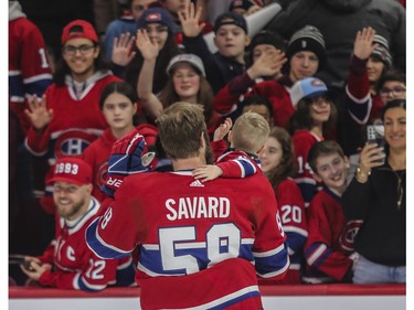 Canadiens defenceman David Savard and one of his children wave to fans at the Canadiens skills competition at the Bell Centre in Montreal on Sunday, Feb. 19, 2023.