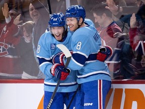 Montreal Canadiens defenceman Mike Matheson, right, and winger Mike Hoffman celebrate Matheson's overtime goal in a 4-3 win over the New York Islanders at the Bell Centre in Montreal on Feb. 11, 2023.