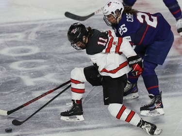 Team Canada's Jill Saulnier pushes away from team USA's Alex Carpenter, during first period action in the final game of the women's hockey Rivalry Series in Laval on Wednesday Feb. 22, 2023.