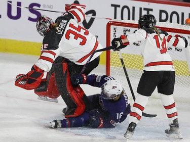 Team Canada goalie Ann-Renée Desbiens steps over team USA Hayley Scamurra while Canada's Renata Fast comes in on the play, during first period action in the final game of the women's hockey Rivalry Series in Laval on Wednesday Feb. 22, 2023.