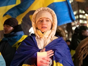 Montrealer takes part in singing of nationalist songs at a candlelight vigil at Dorchester Square on Friday, Feb. 24, 2023, to mark the one-year anniversary of the Russian invasion of Ukraine.