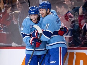 Montreal Canadiens winger Mike Hoffman, left, and defenceman Mike Matheson celebrate Matheson's overtime goal in a 4-3 win over the New York Islanders in Montreal, on Feb. 11, 2023.