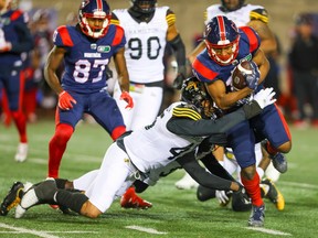 Montreal Alouettes receiver Kaion Julien-Grant is tackled by Hamilton Tiger-Cats linebacker Jovan Santos-Knox during first half in Montreal on Sept. 23, 2022.