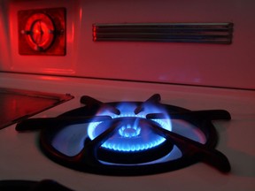 Blue flames rise from the burner of a natural gas stove.