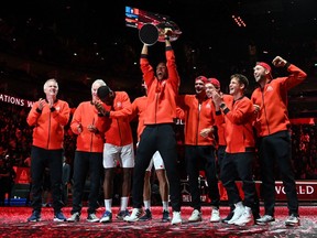 Montreal's Félix Auger-Aliassime lifts the trophy as Team World players celebrate their victory over Team Europe in the 2022 Laver Cup at the O2 Arena in London on Sept.25, 2022.