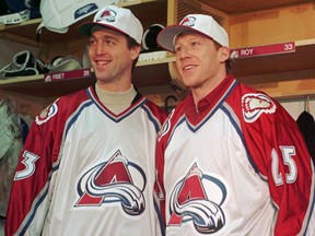 Newly acquired Colorado Avalanche players Patrick Roy, left, and Mike Keane smile as they don their new team's jersey during a news conference in the locker room in Denver's McNichols Sports Arena on Dec. 6, 1995. The two were traded to the Avalanche as part of a five-player deal with the Montreal Canadiens.