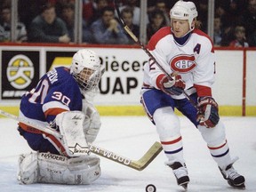 New York Islanders goalie Tommy Soderstrom stops Montreal Canadiens winger Mike Keane in Montreal on Feb. 20, 1995.