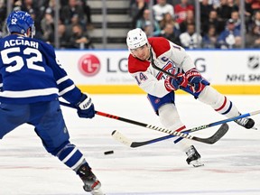 Canadiens forward Nick Suzuki (14) shoots the puck past Toronto Maple Leafs forward Noel Acciari (52) in the second period at Scotiabank Arena in Toronto on Saturday, Feb. 18, 2023.