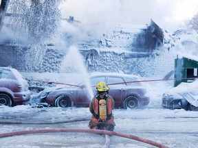 Firefighters battle a five-alarm blaze in an apartment building in Montreal on Friday, Feb. 3, 2023.