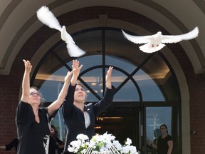 Josée Masson, left, and Marie-Ève Garneau release two doves at end of the funerals of Romy and Norah Carpentier, at the funeral home in Levis, Que., Monday, July 20, 2020. Romy and Norah Carpentier were found dead in Saint-Apollinaire, Que.