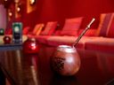 Yerba mate, a hot South American herbal infusion, sometimes called the drink of the gods, is seen served the traditional way: in a gourd with a bombilla (metal straw).