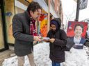 Christopher Baenninger, Liberal candidate in the upcoming byelection in the riding of Saint-Henri-Sainte-Anne, speaks with voter Afnan Omar while campaigning on Notre-Dame St. in Montreal Thursday March 2, 2023.