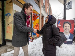 Christopher Baenninger, the Liberal candidate for the March 13 byelection in Saint-Henri—Sainte-Anne riding, speaks with voter Afnan Omar while campaigning on Notre-Dame St. on March 2, 2023.