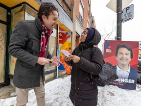 Christopher Baenninger, Liberal candidate for the byelection in the riding of Saint-Henri—Sainte-Anne, speaks with voter Afnan Omar while campaigning on Notre-Dame St. in Montreal, Thursday March 2, 2023.