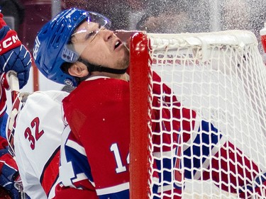 Canadiens' Nick Suzuki hits his head on the crossbar as he crashes into Carolina Hurricanes net  during first period of National Hockey League game in Montreal Tuesday March 7, 2023.