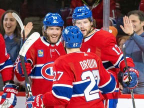 Montreal Canadiens' Mike Hoffman, left, celebrates his first-period goal with teammates Josh Anderson and Jonathan Drouin during game against the Carolina Hurricanes in Montreal on March 7, 2023.