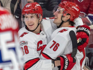 Carolina Hurricanes' Brady Skjei, right, celebrates his second-period goal against the Montreal Canadiens with teammate Martin Necas during National Hockey League game in Montreal Tuesday March 7, 2023.