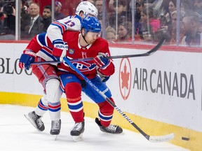 New York Rangers' Alexis Lafreniere reaches around Montreal Canadiens' Mike Matheson during the second period of a National Hockey League game in Montreal Thursday March 9, 2023.