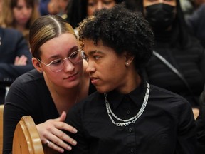 Ella Cantone, a friend of Nicholas Gibbs, who was fatally shot by Montreal police in Montreal's Notre-Dame-de-Grâce area in August 2018, comforts Jade Hunte at an event for crime victims on Friday, March 10, 2023, at Union United Church in Montreal. Hunte was three years old when her father, Andrew, 22, was shot dead in 2008 after attempting to break up a fight. Friday's event was the first part of the Community Safety and Crime Prevention Initiative organized by the Center for Research-Action on Race Relations.