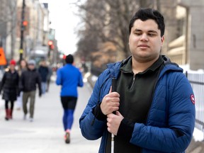 Rashad Naqeeb in the foreground in a blue jacket holding a white cane. In the background, a busy downtown Montreal street