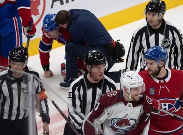 Montreal Canadiens centre Rem Pitlick (32) is attended to as referees escort Colorado Avalanche defenceman Devon Toews (7) to the penalty box for boarding during first-period NHL action at the Bell Centre in Montreal on Monday March 13, 2023.