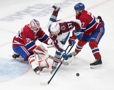 Montreal Canadiens left wing Jonathan Drouin (27) checks Colorado Avalanche left wing J.T. Compher (37) off the puck as he crosses in front of Montreal Canadiens goaltender Sam Montembeault (35) during second-period NHL action at the Bell Centre in Montreal on Monday March 13, 2023.