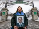 Evanthia Karassavidis holds of photo of her late father, Logothetis, outside the locked gates of Notre-Dame-des-Neiges cemetery in Montreal on Thursday March 16, 2023. Her father died in February, but his body can't be buried because of a strike at the cemetery.