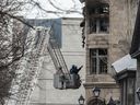 On Sunday, March 19, 2023, inspectors look inside the building on Place d'Youville in Old Montreal that was destroyed by fire last Thursday.