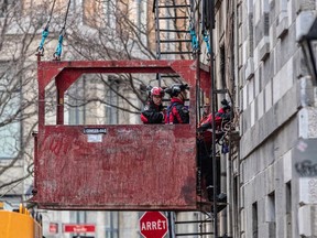 Firefighters have been using drones, cameras and a search crew suspended in a basket to search through the Old Montreal heritage building that caught fire last week, killing at least four people, with three more missing and presumed dead.