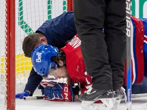 Montreal Canadiens' Josh Anderson is attended to by head athletic therapist Graham Rynbend after being taken down by Tampa Bay Lightning's Mikhail Sergachev during third period of National Hockey League game in Montreal Tuesday March 21, 2023.