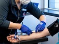 A Héma-Québec nurse disconnects a line during a blood donation.