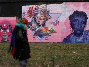 A pedestrian passes street art by members of the WOM collective, created for International Women's Day, in east London on March 6, 2023.
