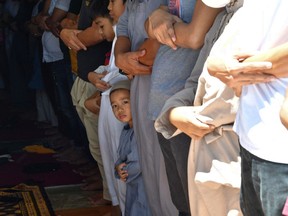 A Muslim child prays along with his relatives at a mosque on the second day of the Muslim holy month of Ramadan in Taguig City in suburban Manila.