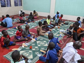 Muslim children wait for the breaking of the fast on the second day of the holy month of Ramadan at a mosque in Treicheville, a popular commune in Abidjan.
