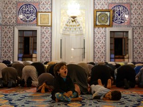 A child is a bit sleepy during prayers on first day of the holy month of Ramadan at Nizamiye Mosque in Midrand, South Africa.