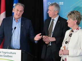 Quebec Minister of Agriculture André Lamontagne, centre, and federal Minister of Agriculture Marie-Claude Bibeau look on as Martin Caron, general president of the Union des producteurs agricoles (UPA), speaks during a news conference in Montreal, Monday, March 27, 2023, where a major investment agreement between the governments of Quebec and Canada in the field of sustainable agriculture was announced.